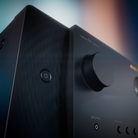 Close-up of a black Marantz Cinema 60 Series 2 AV Receiver showing the power button and front control dial against a blurred background.
