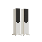 A pair of floorstanding speakers with tall white cabinets, black front baffle panels, and small white feet, shown against a plain white background.