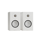 A pair of white bookshelf speakers with black-rimmed circular drivers and small gold-toned tweeters, shown against a plain white background.