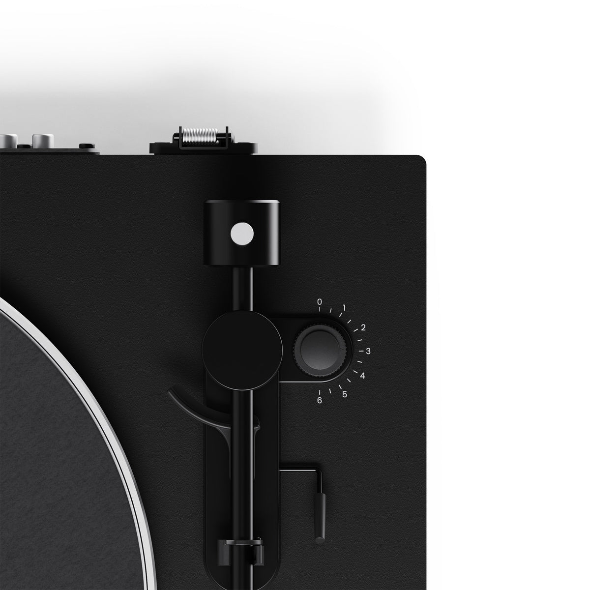 Close-up of a black turntable with control knobs on a white background