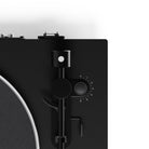 Close-up of a black turntable with control knobs on a white background