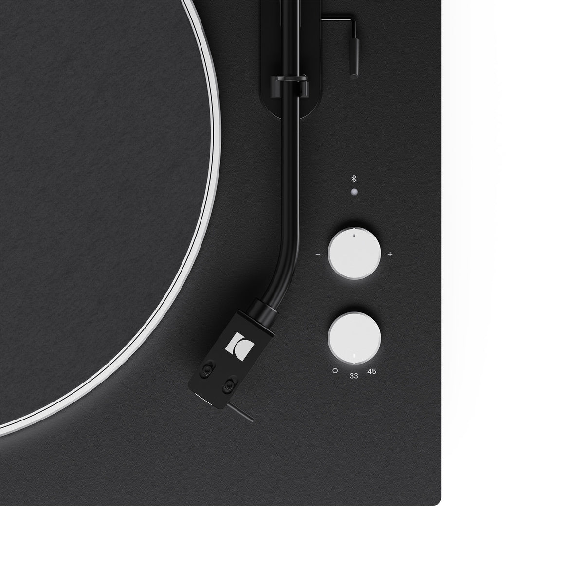 Close-up of a black turntable with white control knobs on a white background