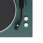 Close-up of a turntable with a green base and white control knobs on a white background