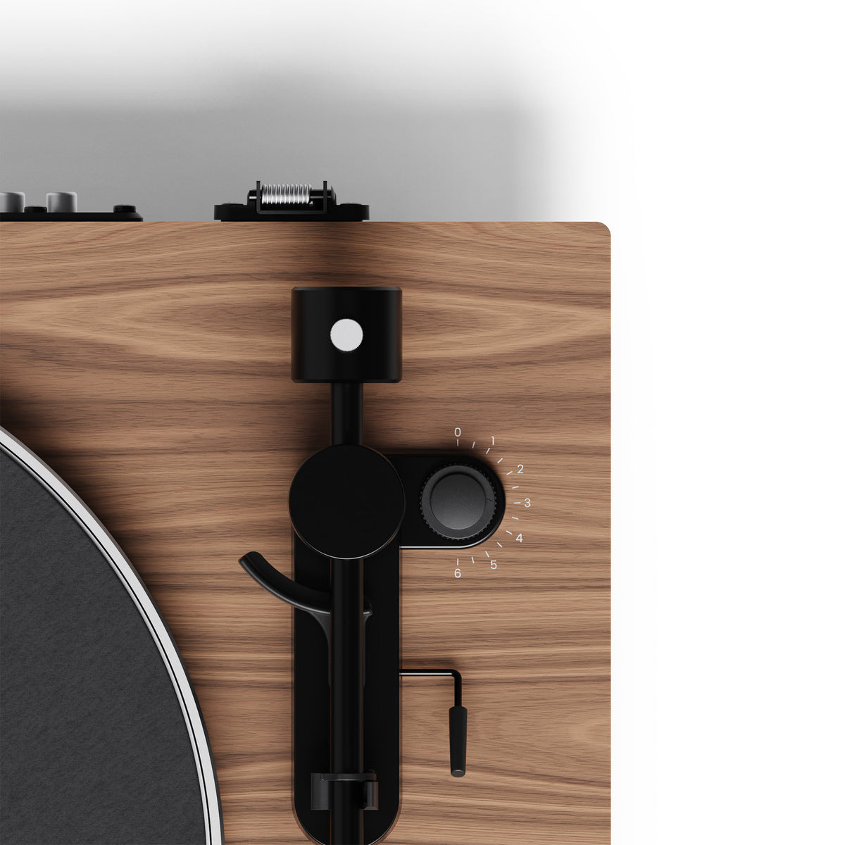 Close-up of a turntable with wooden plinth and black arm on a white background