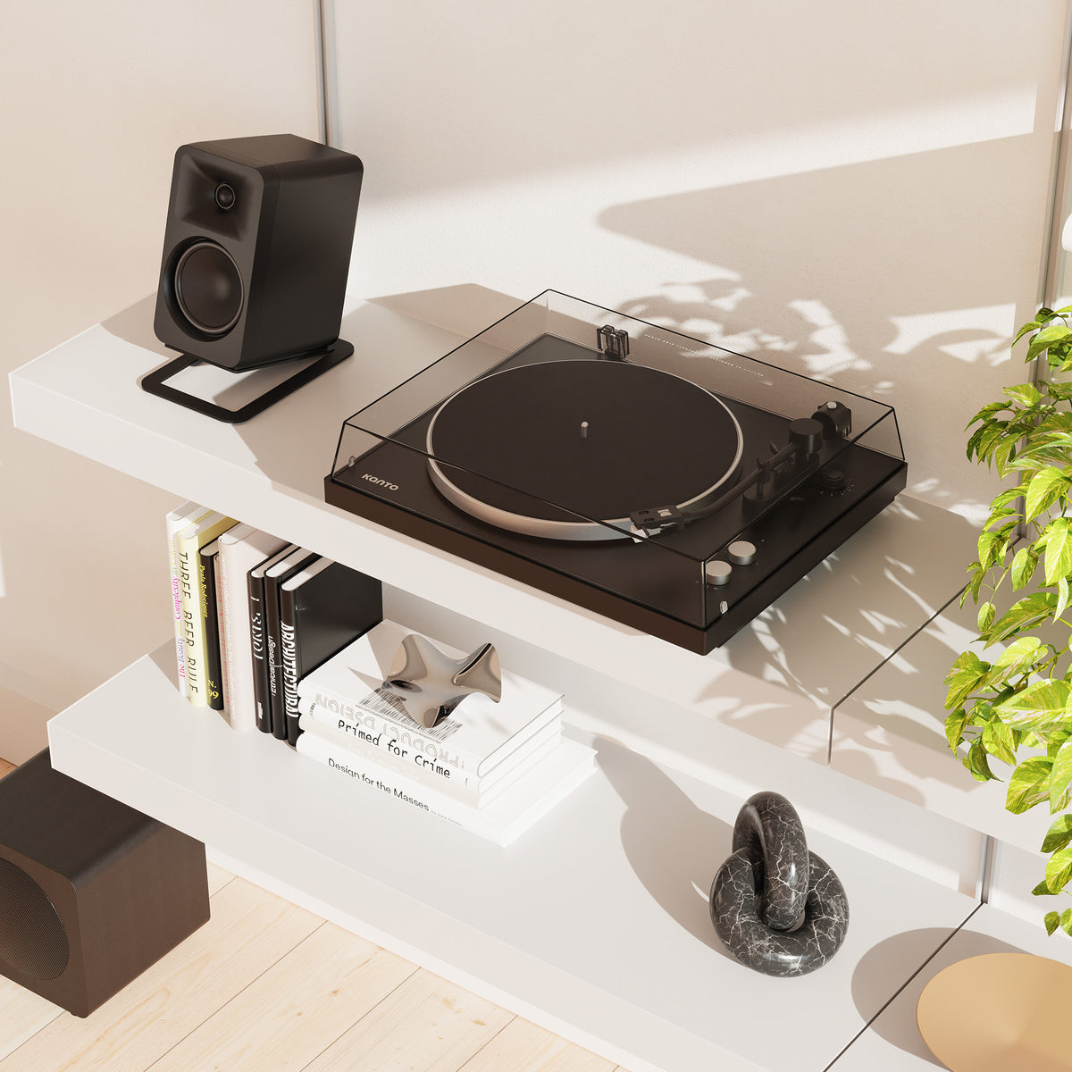 Turntable on a white shelf with books and decor items, in a bright room.