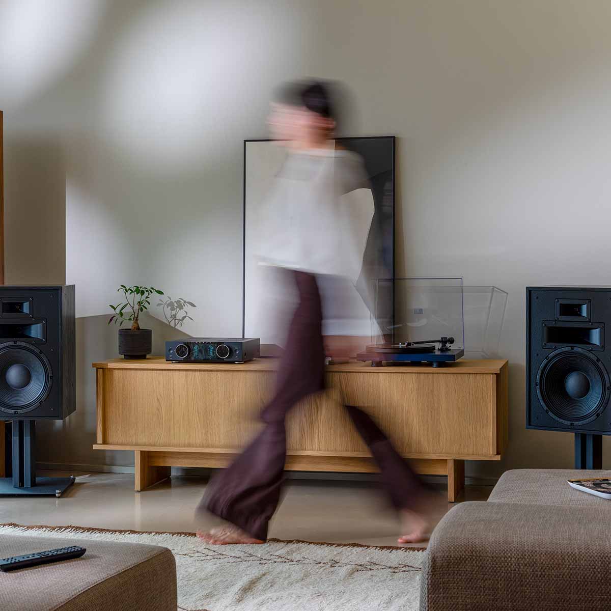 Onkyo Muse Y-40 Network Integrated Amplifier - Black - lifestyle photo of unit on cabinet with walking woman in foreground