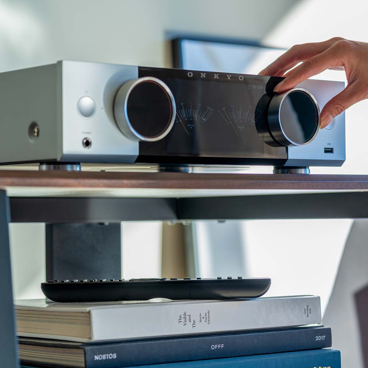 Onkyo Muse Y-50 Network Integrated Amplifier - Silver - lifestyle view of unit on shelf with hand adjusting left knob