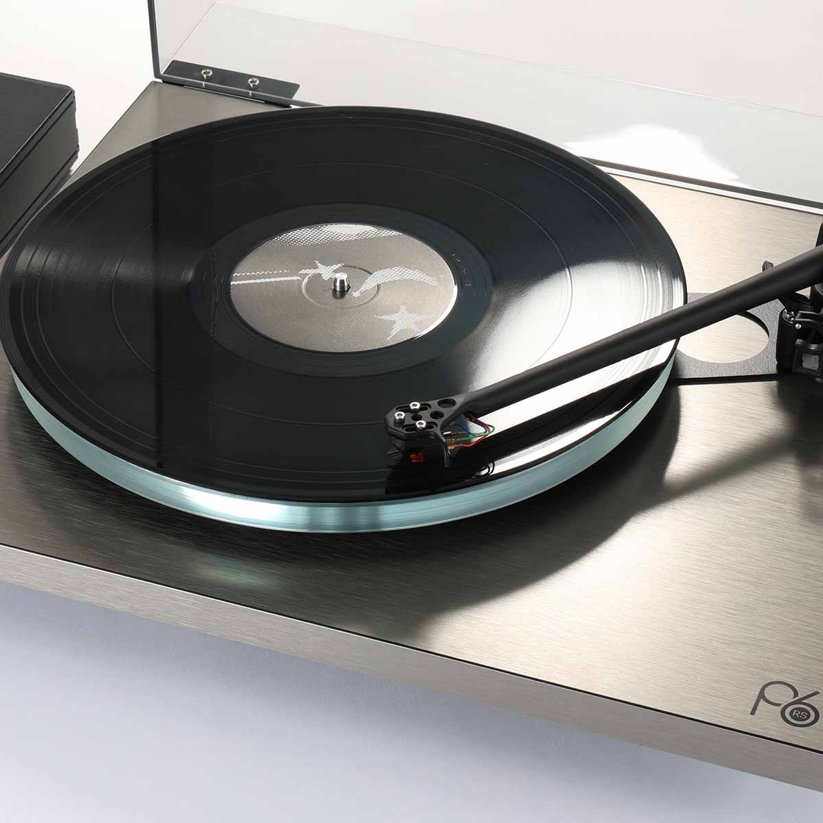 Rega Planar 6 RS Special Edition Turntable - high-angle close-up three-quarter view with open dustcover and record on platter with tone arm engaged