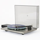 Rega Planar 6 RS Special Edition Turntable - front view with open dustcover and record on platter with tonearm engaged, separate phono stage to left, both units angled left