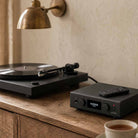 Audiolab PPA7 Phono Preamplifier - Black - lifestyle photo of unit on cabinet to right of turntable