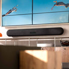 Bluesound Pulse Cinema Multi-Room Streaming Soundbar lifestyle photo of unit wall mounted under TV