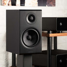 Rotel Amora 5 Passive Bookshelf Loudspeakers - Black - Lifestyle photo front and side view angled right without grille