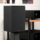 Rotel Amora 5 Passive Bookshelf Loudspeakers - Black - Lifestyle photo front and side view angled right with grille