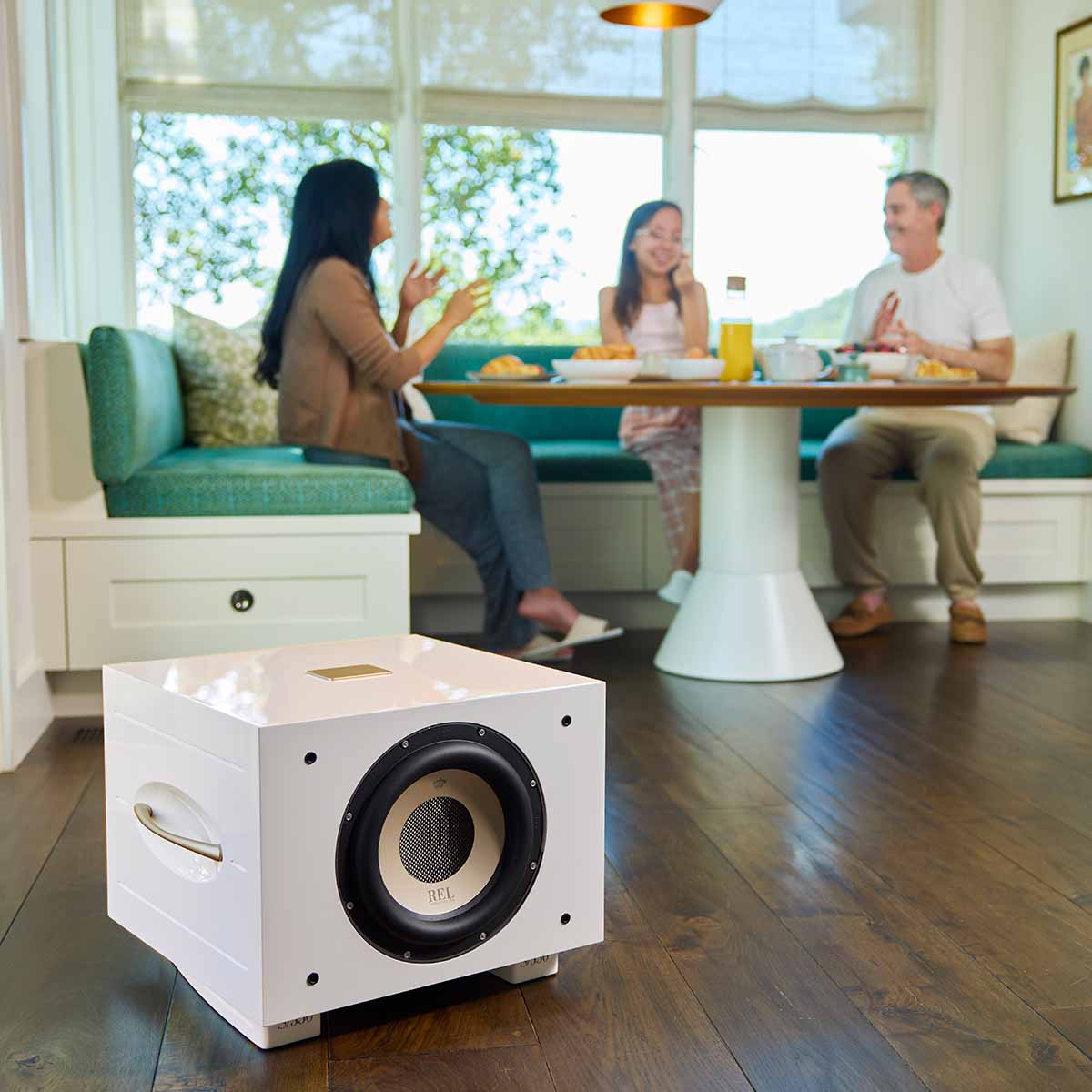 REL Acoustics S/550 Subwoofer - white - lifestyle photo front view angled right without grille in kitchen in front of table