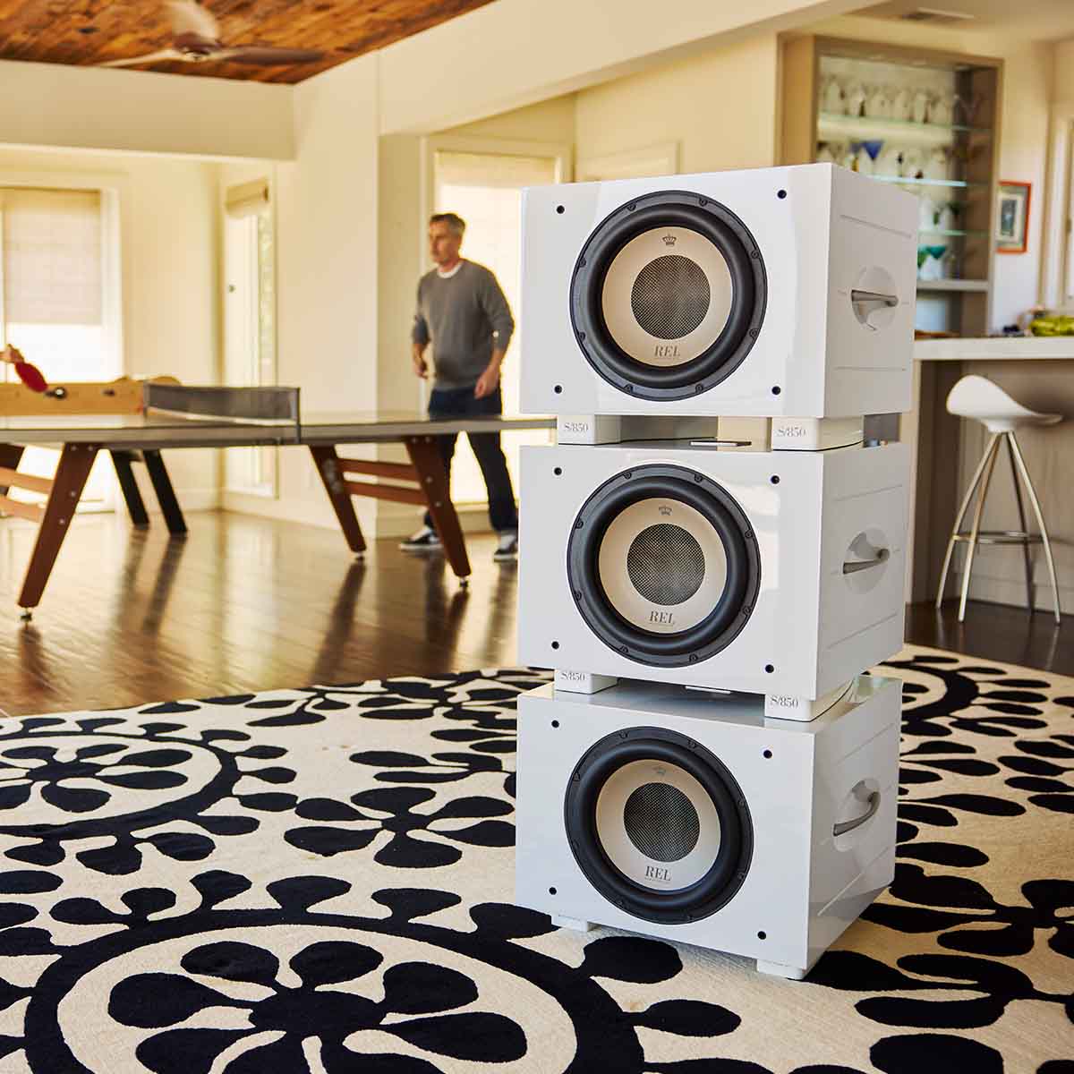 REL Acoustics S/850 Subwoofer - white - lifestyle photo of stack of three subwoofers in house without grilles