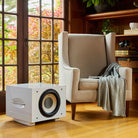 REL Acoustics S/850 Subwoofer - white - lifestyle photo of subwoofer next to chair without grille