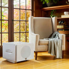REL Acoustics S/850 Subwoofer - white - lifestyle photo of subwoofer next to chair with grille