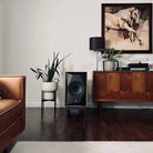 MoFi Electronics SourcePoint 10 Master Edition Bookshelf Speakers - walnut - lifestyle photo single speaker on stand next to cabinet
