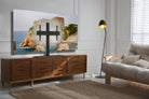 Living room with a large TV displaying a scenic image, wooden sideboard, and beige sofa.