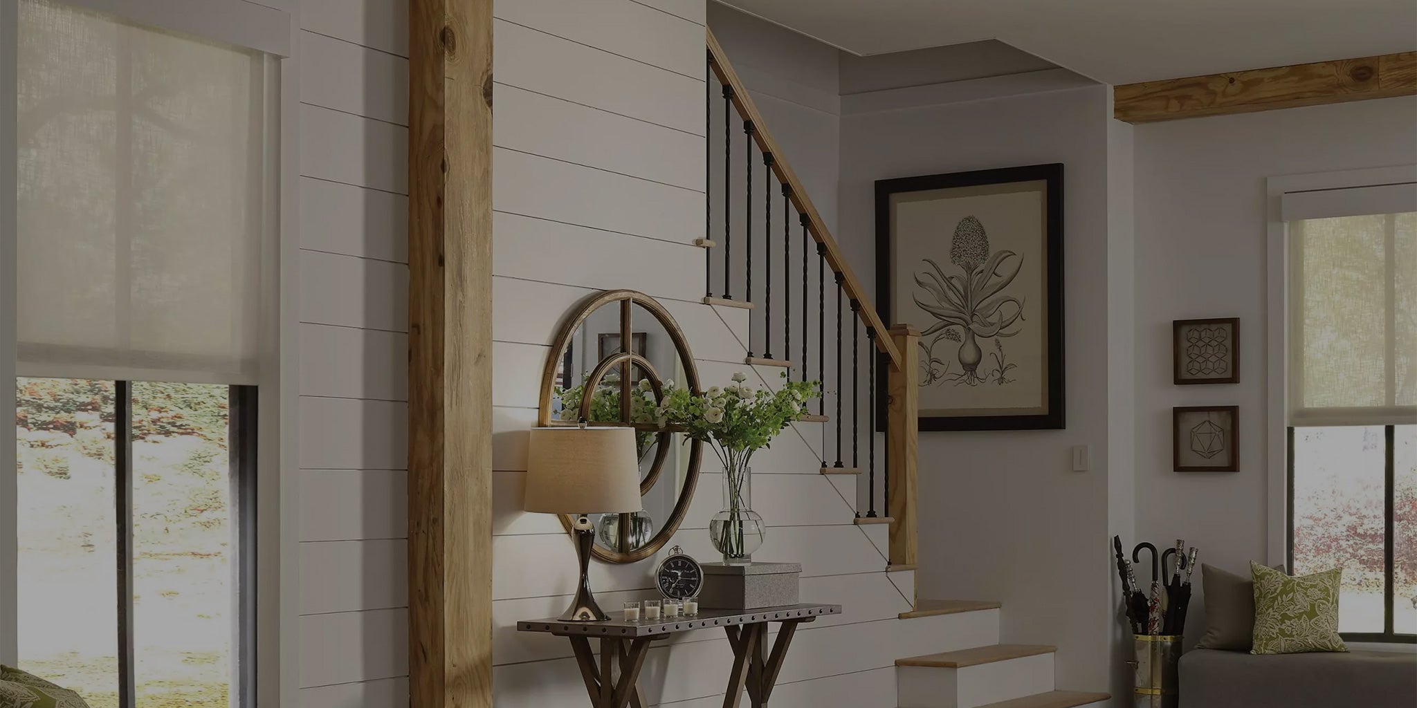 Hallway and staircase in a home with motorized shades on the windows