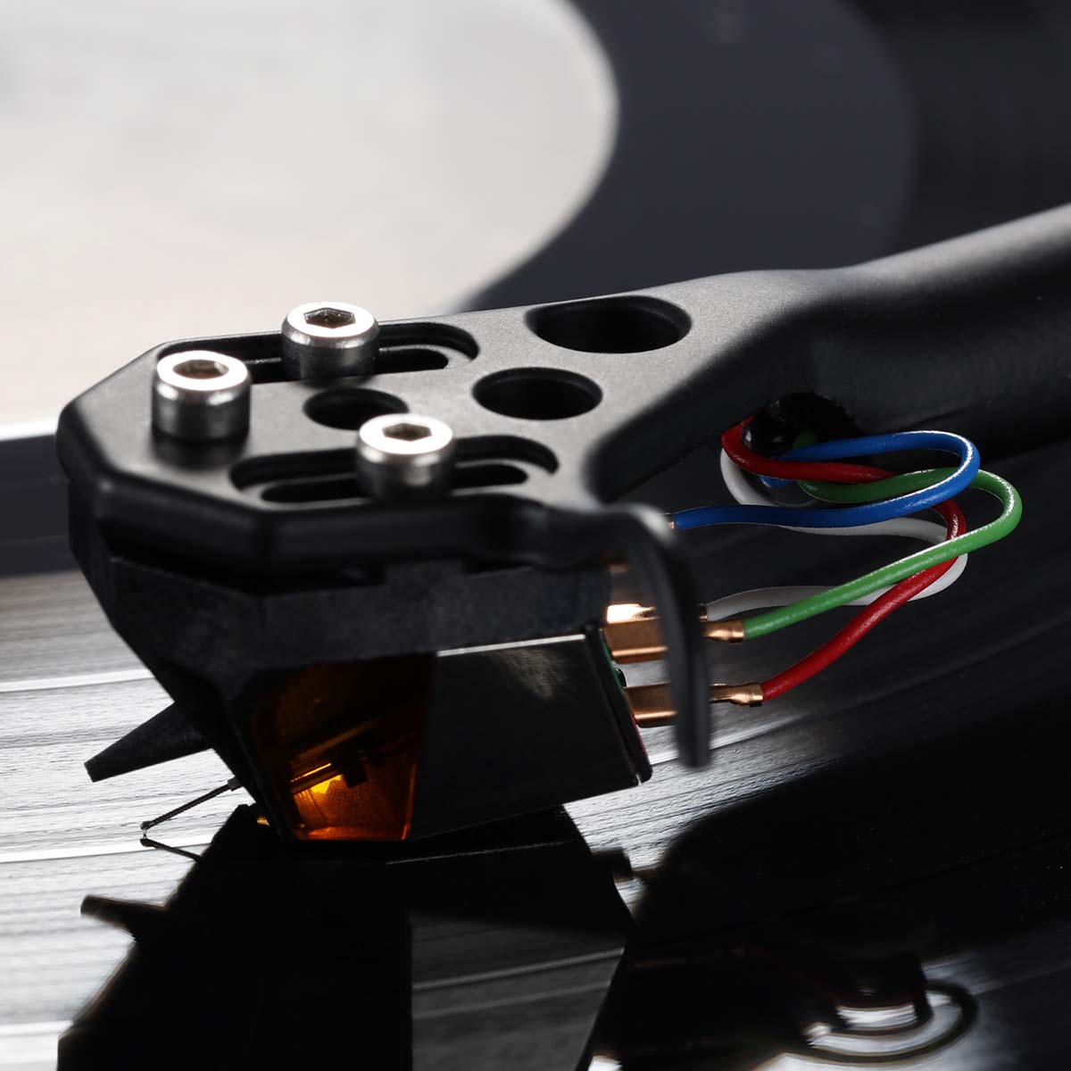 Rega ND9 Moving Magnet Phono Cartridge - side and top view of cartridge mounted on tone arm with needle on record