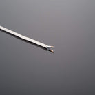 White cable with exposed copper wires on a dark gray background