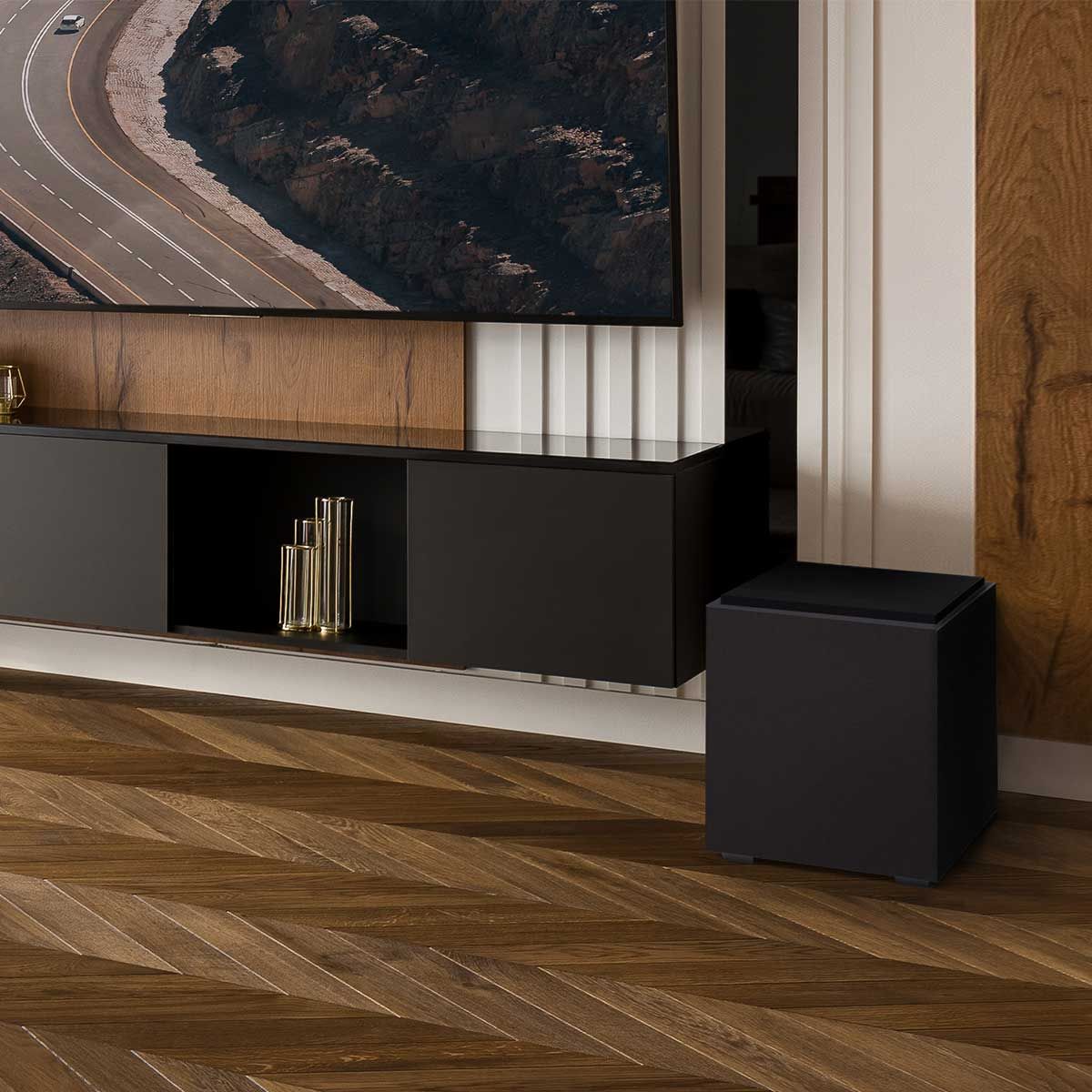 Definitive Technology Descend 10" Subwoofer, Midnight Black, set up beside a black media cabinet and large television in a wood-paneled living space