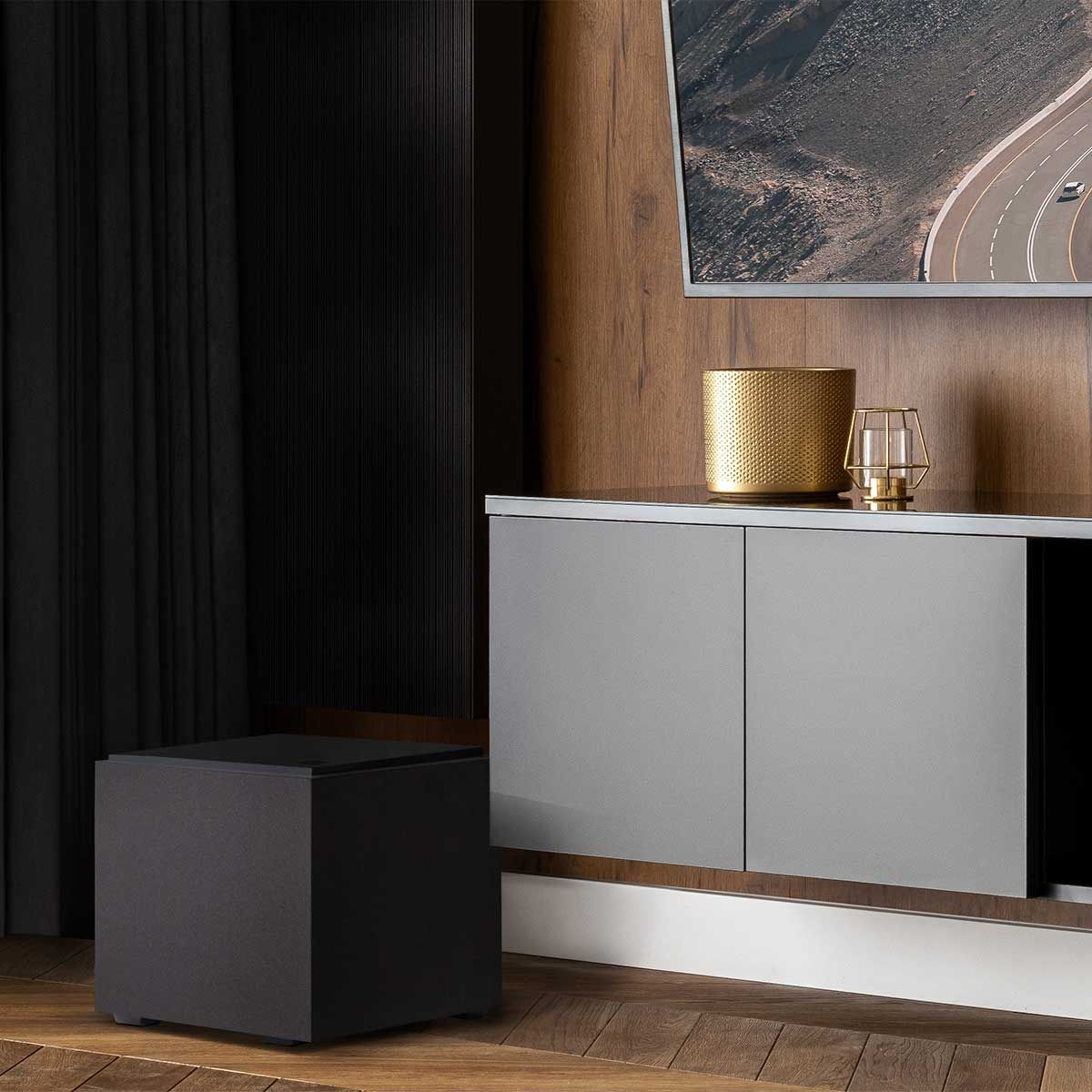 Definitive Technology Descend 8" Subwoofer, Midnight Black, set up near a light grey sideboard in a living room space