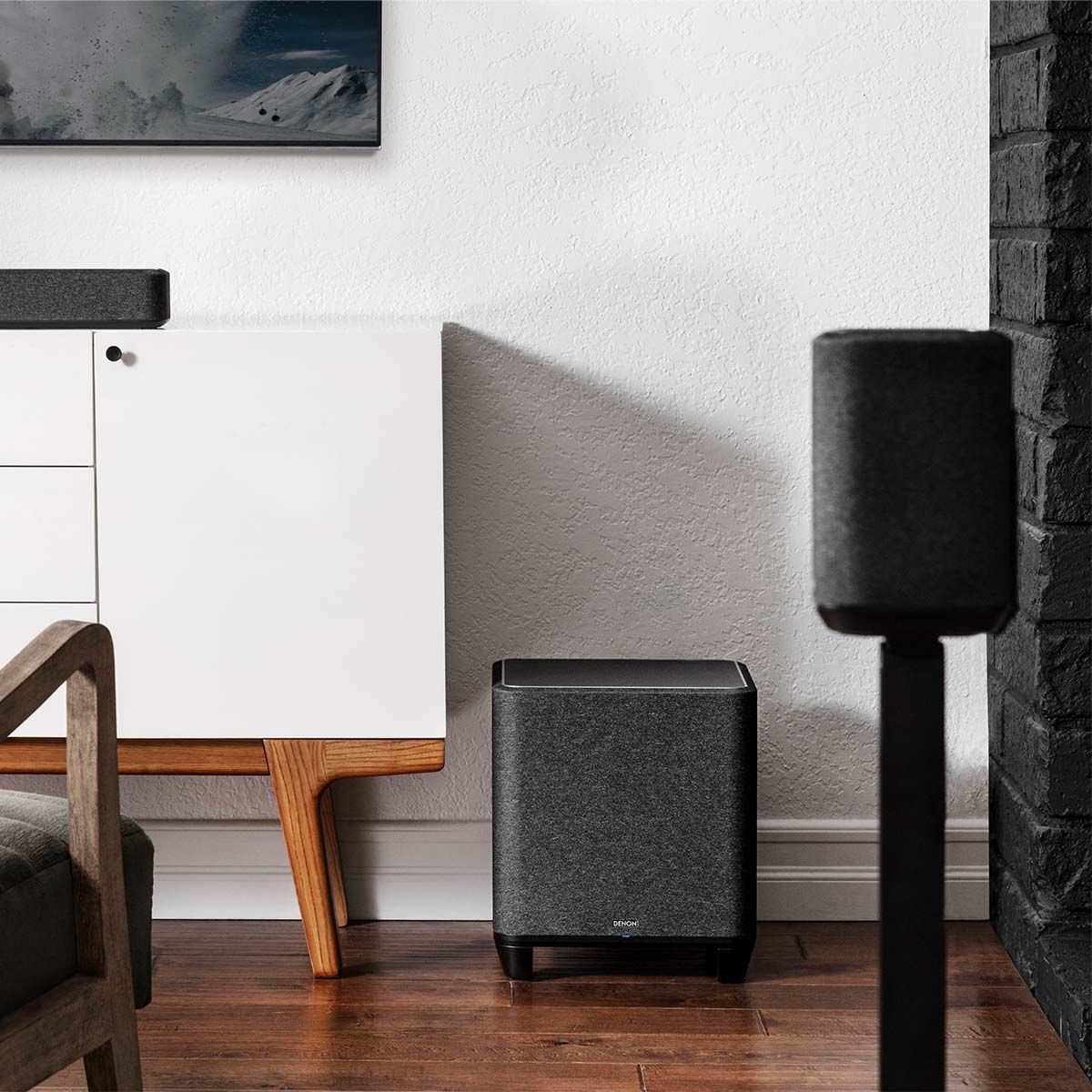 Denon Home Wireless Subwoofer, in a room with other Denon surround sound products