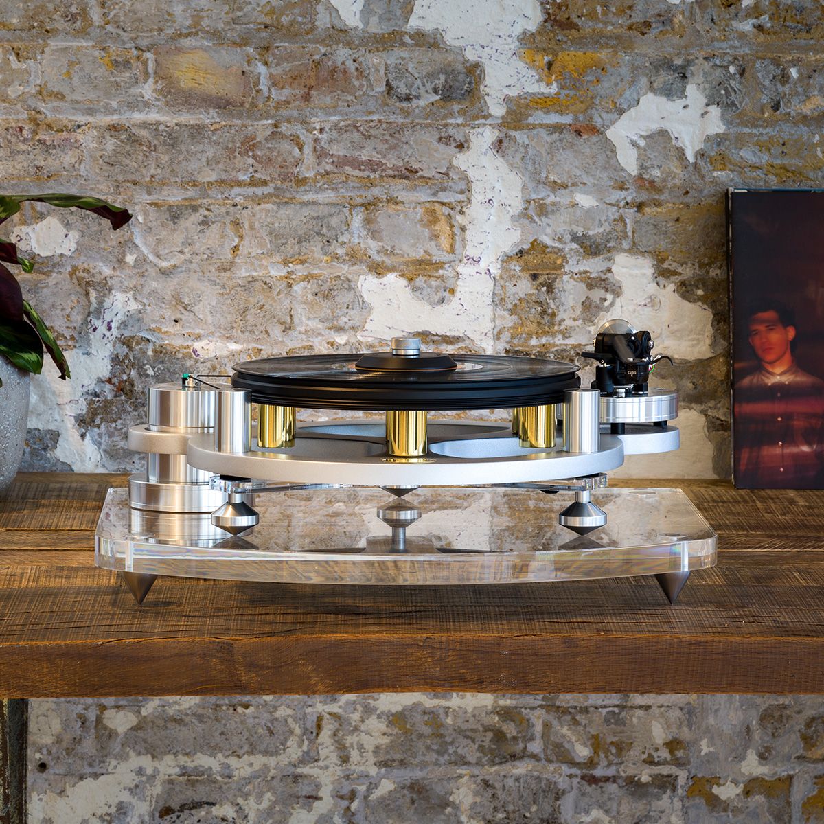 Michell Gyro SE turntable in silver on Iso Base sitting on table in front of brick wall
