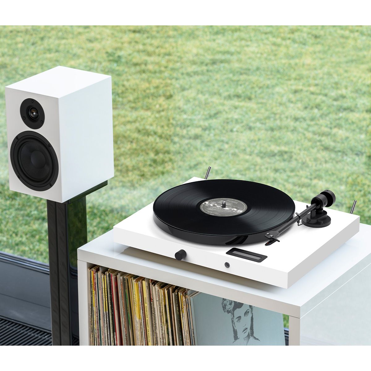 Pro-Ject Juke Box E1 Turntable in white on cabinet connected to speakers