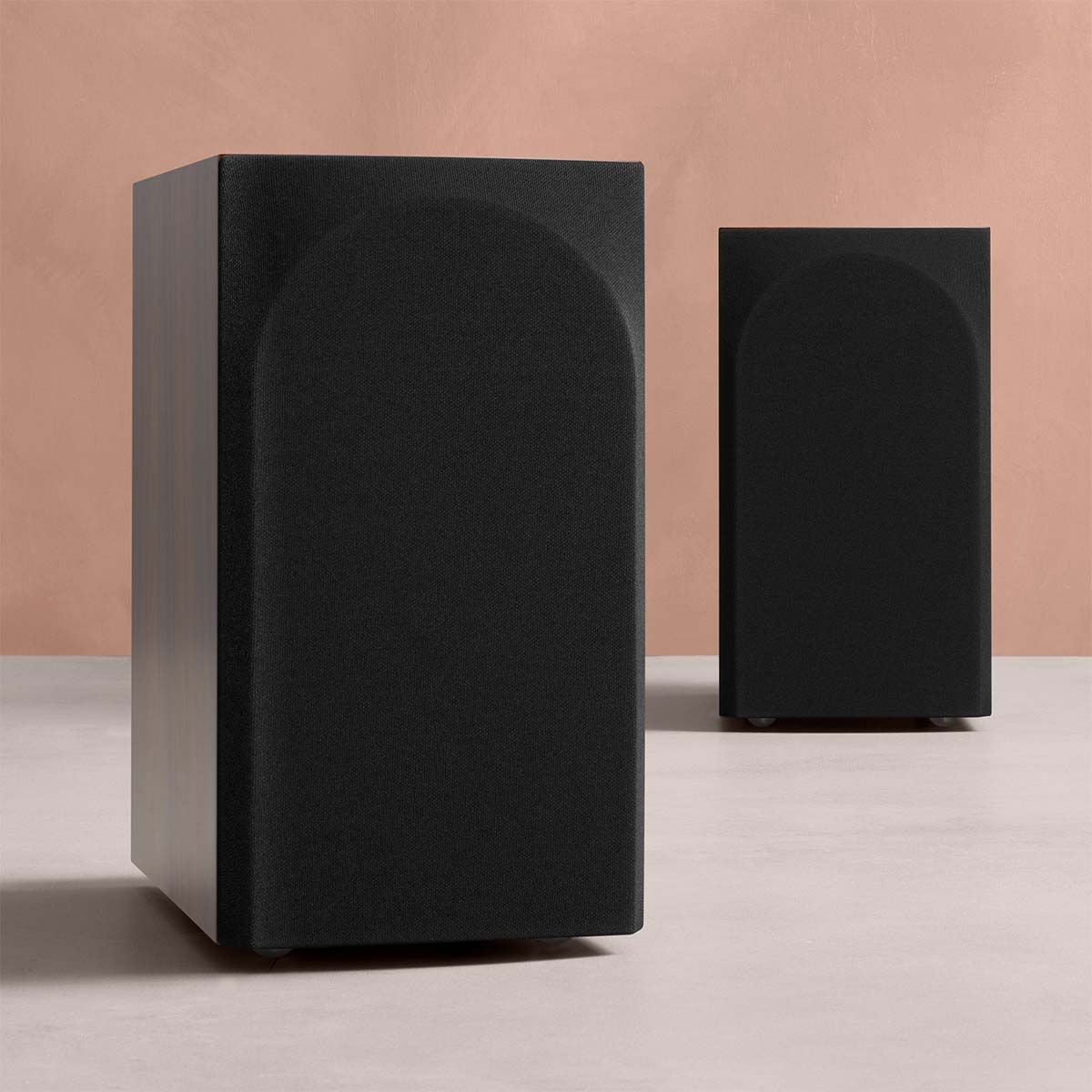 Bowers & Wilkins 706 S3 2-Way Stand Mount Bookshelf Loudspeakers in black with grilles on table with orange background