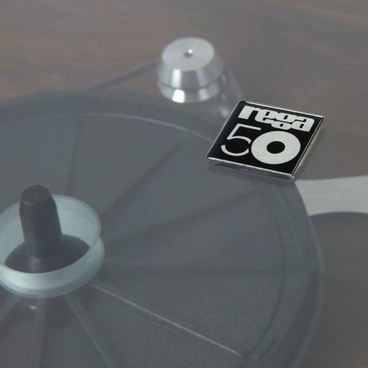 Rega Planar 3 50th Anniversary Edition Turntable - Walnut close-up of 50th anniversary badge on dustcover