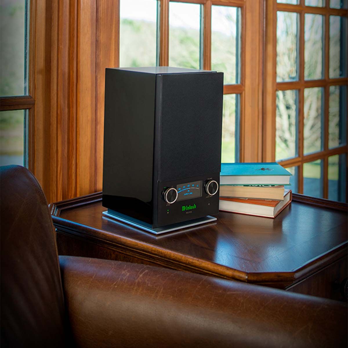 McIntosh RS150 Wireless Speaker, in a library on a table beside some books