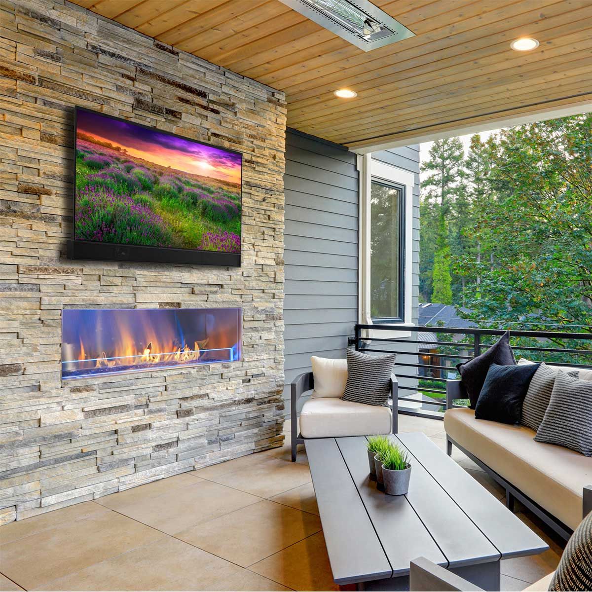 Séura Shade Series 2 4K UHD Outdoor TV, wall-mounted above a fireplace on a patio