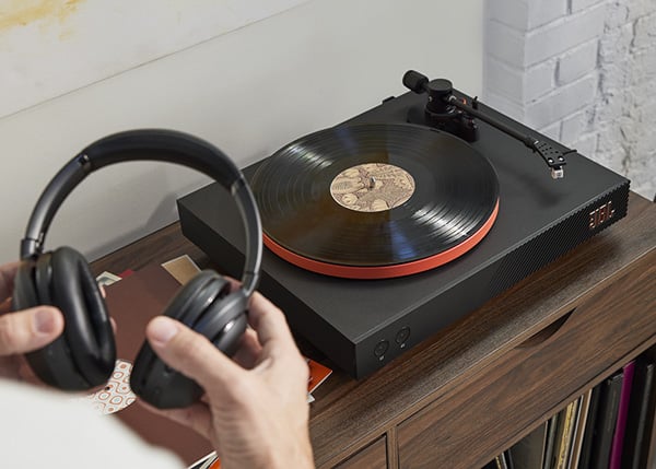 JBL Spinner turntable on a wood cabiner with headphones in the foreground