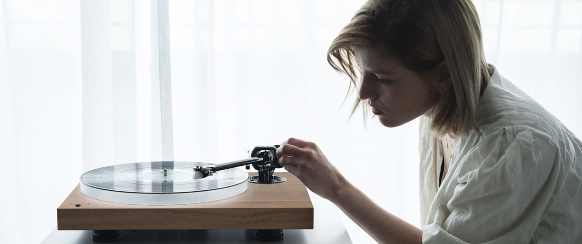 Pro-Ject X1B turntable being adjusted by a blonde worman
