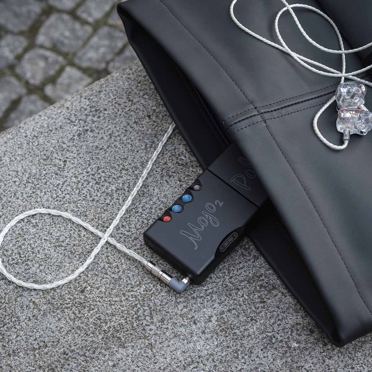 Chord Mojo 2 connected to in-ear headphones in a purse outside