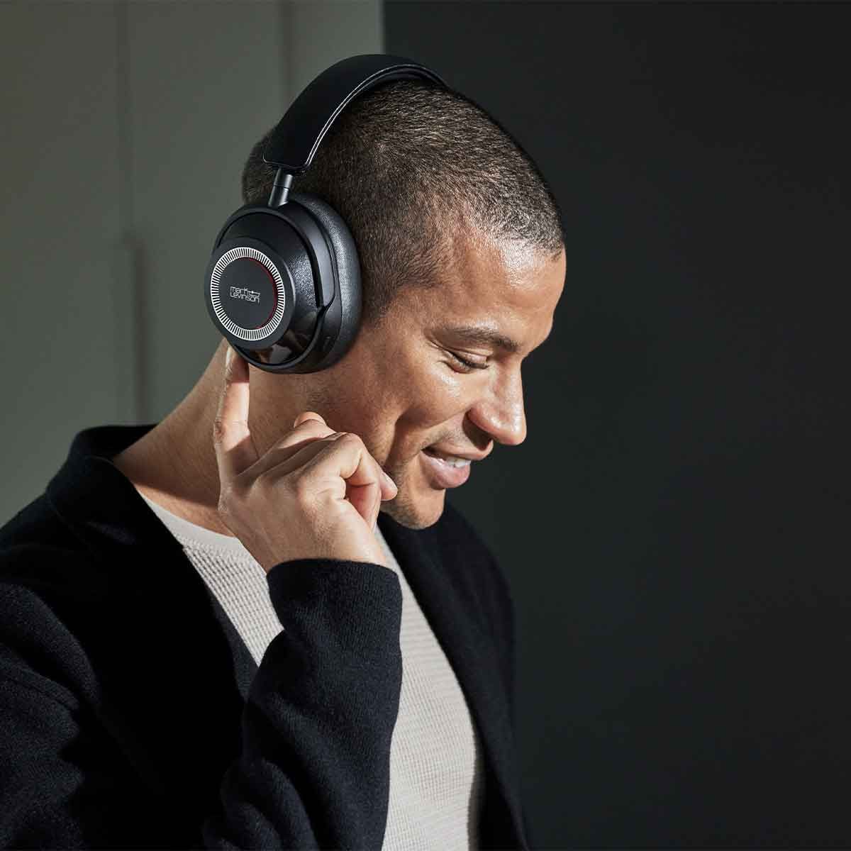Male model wearing a pair of Mark Levinson № 5909 Premium Hi-Res Wireless ANC Over-Ear headphones in the Pearl Black finish.
