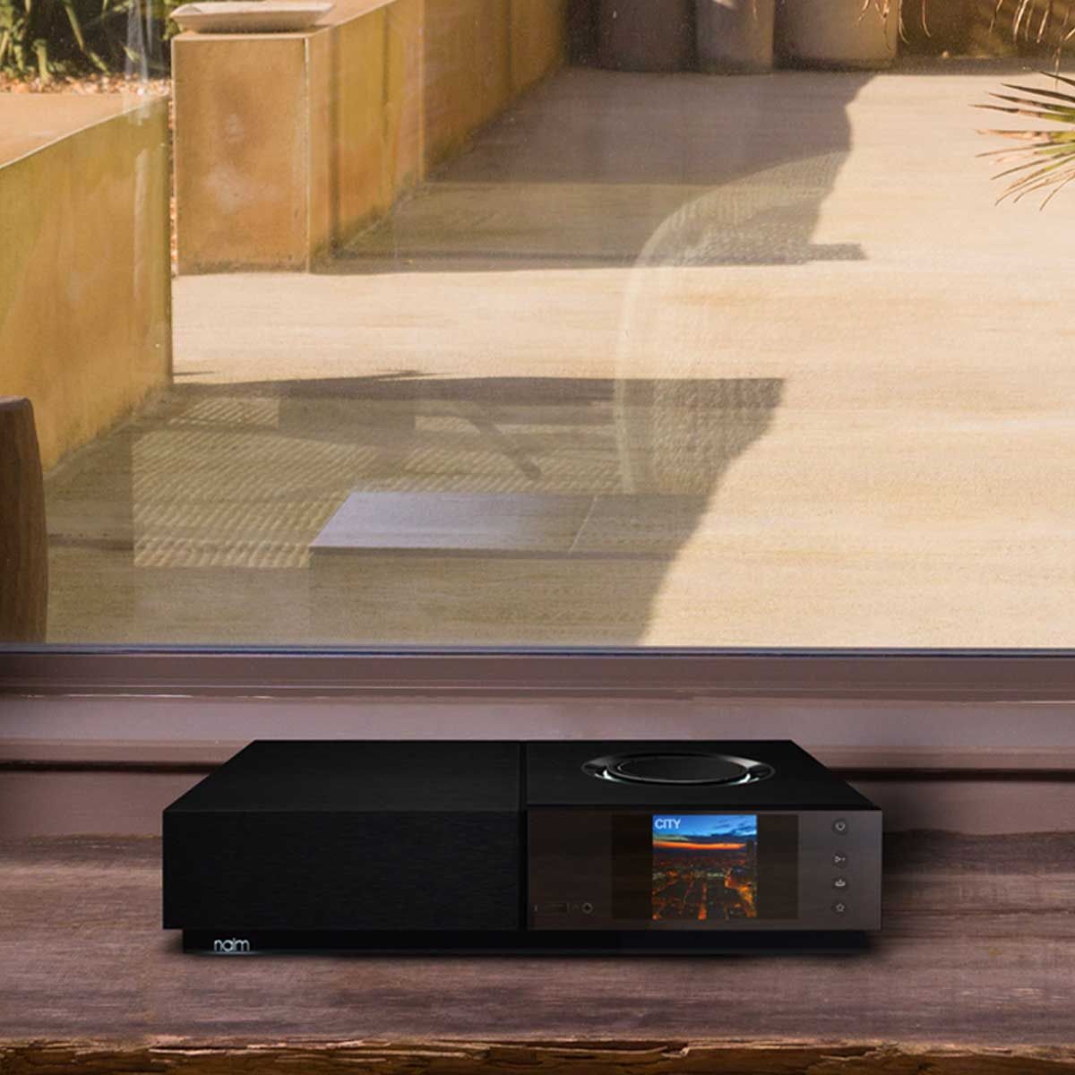 Naim Uniti Nova Integrated Amplifier sitting on a table in front of a window