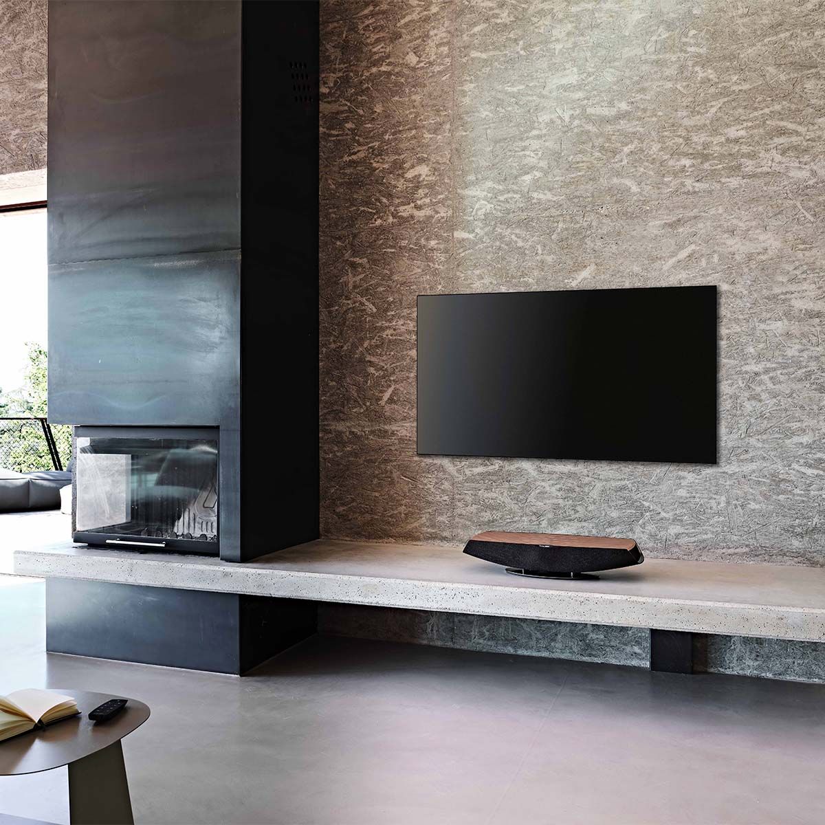 Sonus Faber Omnia Wireless Smart Speaker, Walnut, on a marble media stand beneath a wall-mounted television