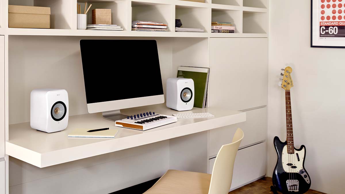 White LS50 Meta Bookshelf speakers on stands connected to turntable