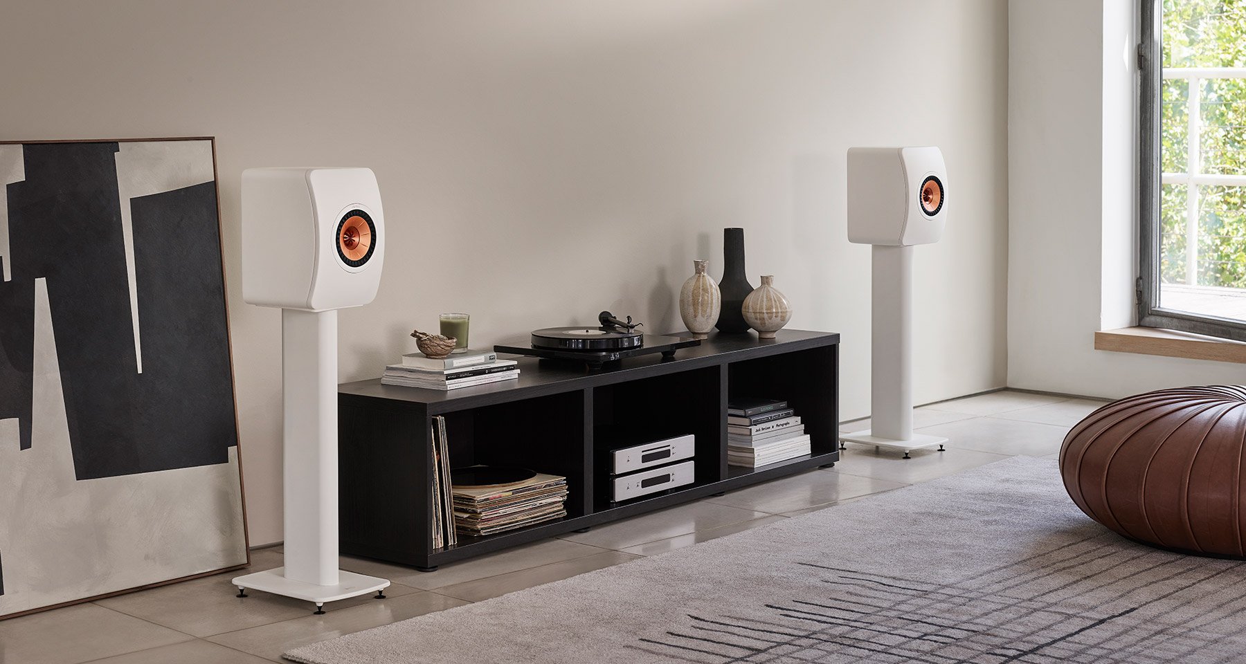 White LS50 Meta Bookshelf speakers on stands connected to turntable