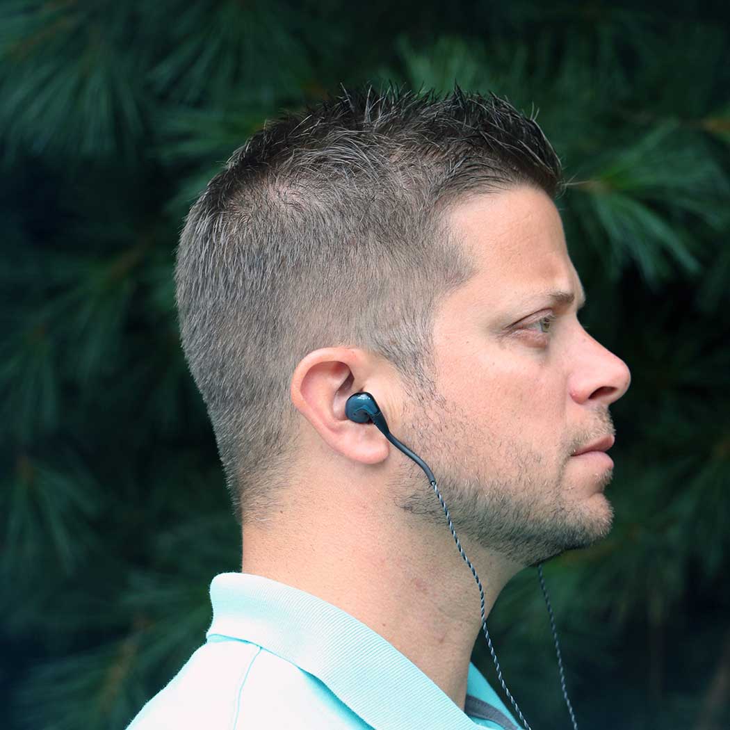 side profile of a male model wearing in-ear headphones, earphones or IEMs.