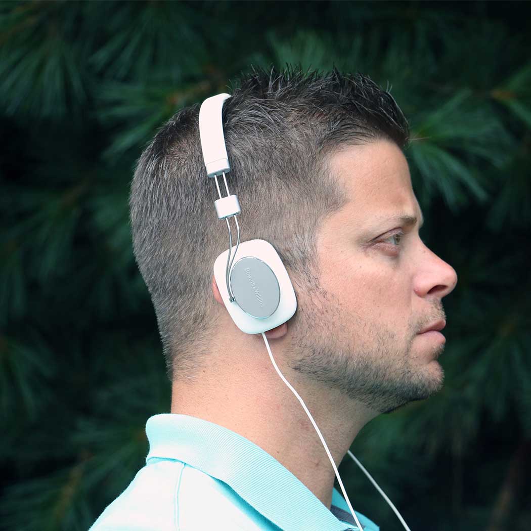 side profile of a male model wearing on-ear headphones or headsets.