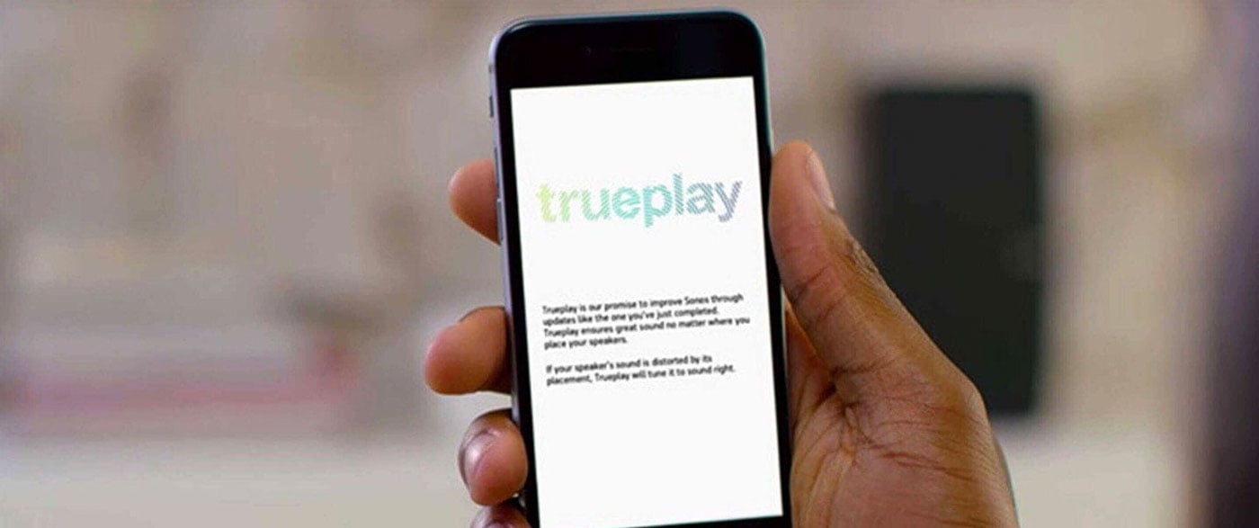 Hand holding phone showing Trueplay technology