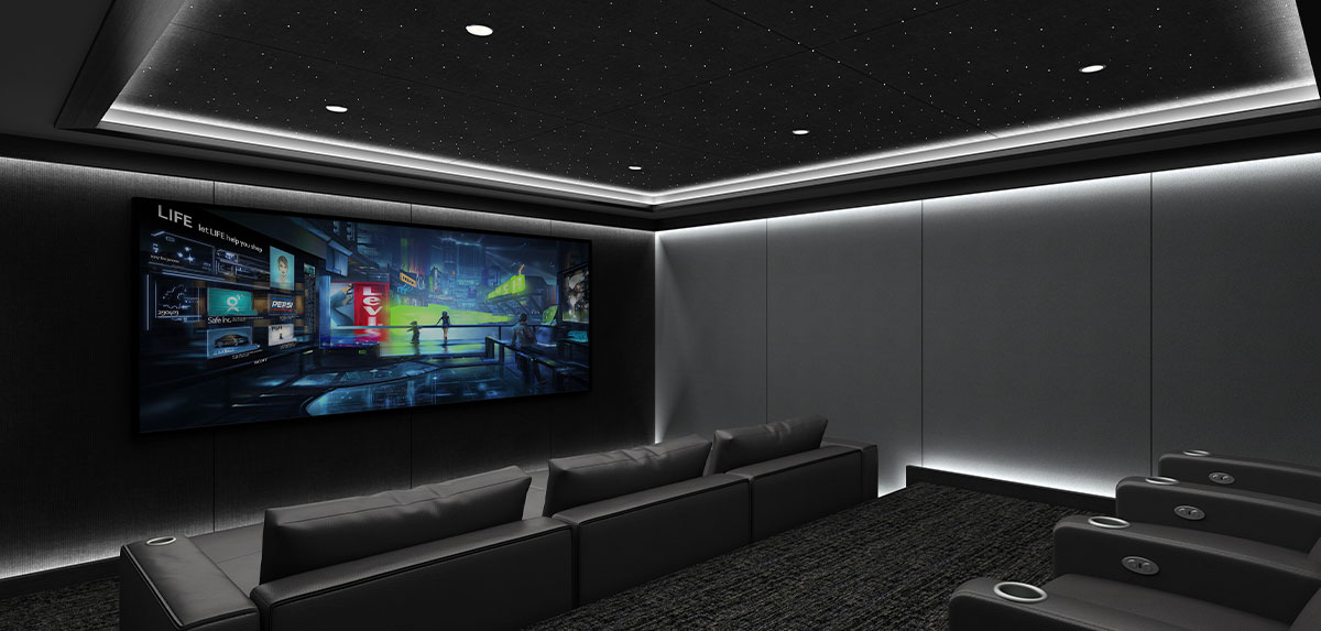 Dark home theater with lighting around the edges of the ceiling and risers