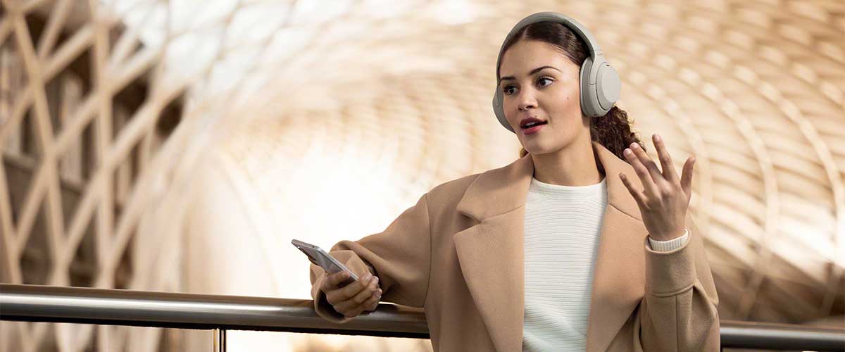 woman talking on the phone and wearing a pair of Sony WH-1000XM4 noise cancelling headphones