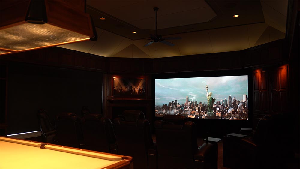 Photo of a projector screen & artwork in home theater room after dmf high-performance lighting is added with lights dimmed for movie