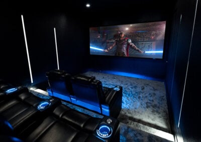 Photo of home theater at an angle with Audio Advice Revolution chairs and Thor on screen
